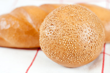 Sliced bread and bun with sesame seeds