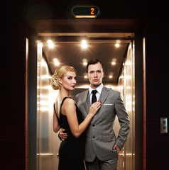 Retro couple standing against elevator. © Nejron Photo