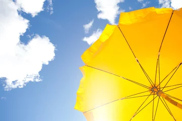 Fotobehang yellow umbrella on blue sky with clouds © matusciac