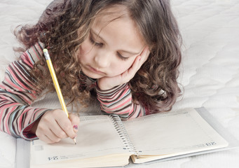 little girl with notebook and pen