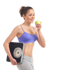 A young brunette woman in sporty clothes holding weight scales