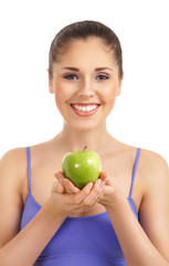 A young and fit woman holding a green apple
