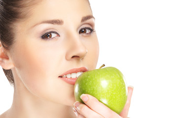 Portrait of a young woman eating a fresh green apple