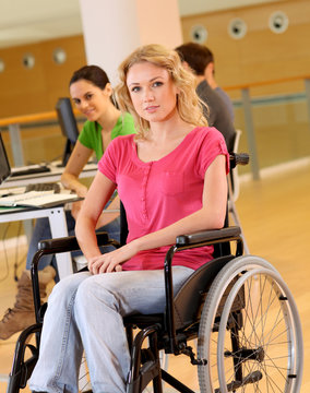 Young woman in wheelchair working in office