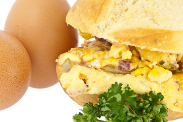 Scrambled eggs on a roll with raw eggs (with clipping path)