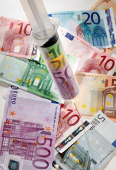 Eine Spritze mit Geldscheinen