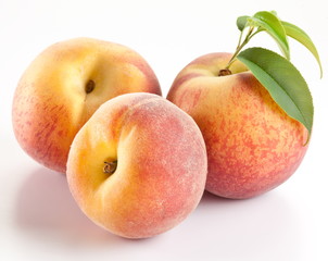 Three ripe peach with leaves