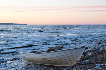 Fishing boat on the bank of the frozen sea