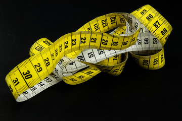 Messy tape measure on black