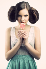 vintage girl with lollipop, she looks at right, she has a sly ex