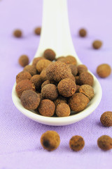 Allspice in a white spoon