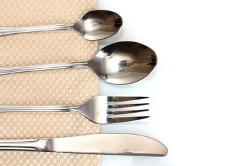 Fork, spoon and knife on a beige tablecloth