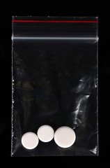 drugs in package on black background