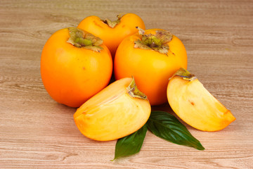 Appetizing persimmons on wooden background
