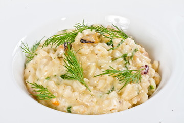 photo of delicious risotto with seafood and dill on it