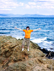 Obraz premium The young man at the sea on a stone