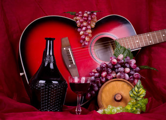 wine, grape and guitar on red background
