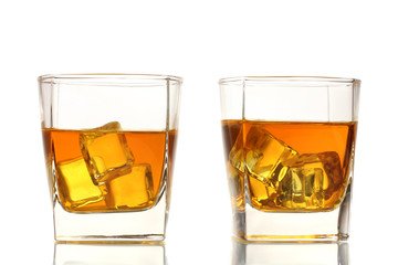 two glasses of scotch whiskey and ice isolated on white