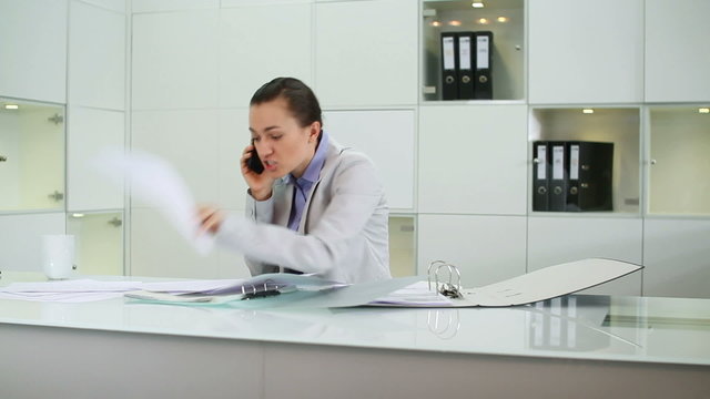 Angry businesswoman with cellphone  in the office