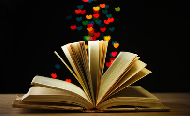 open book on wooden table on bright background