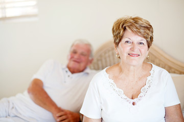 senior couple sitting on bed