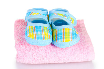 Blue baby booties on pink towel isolated on white