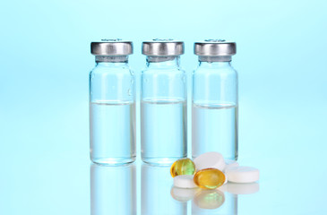 Tablets and ampoules on blue background