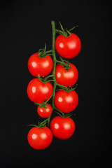 fresh and shiny cherry tomatoes on black background