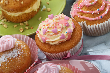 Mit Herzen und Zuckerstreusel verzierte Cupcakes