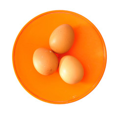 three brown eggs on kitchen scales isolated on white background