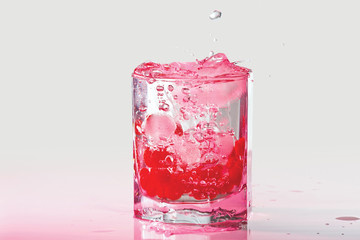 Glass of water, ice and red cranberries with splash