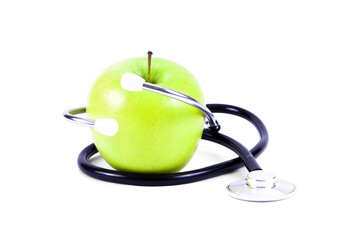 Medical stethoscope and green apples.