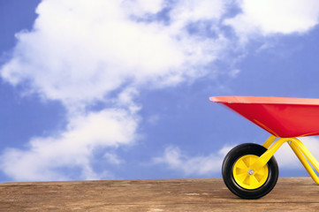 red and yellow wheelbarrow agains a blue sky