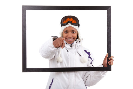 Young smiley woman in ski gears  holding a picture frame