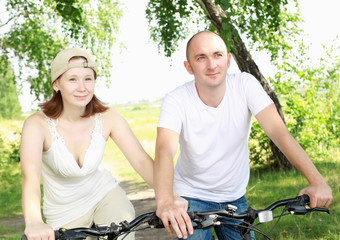 Obraz premium Young couple on the bikes in the park