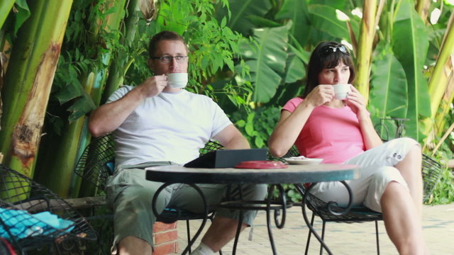 Happy young couple drinking coffee in bar, outdoors