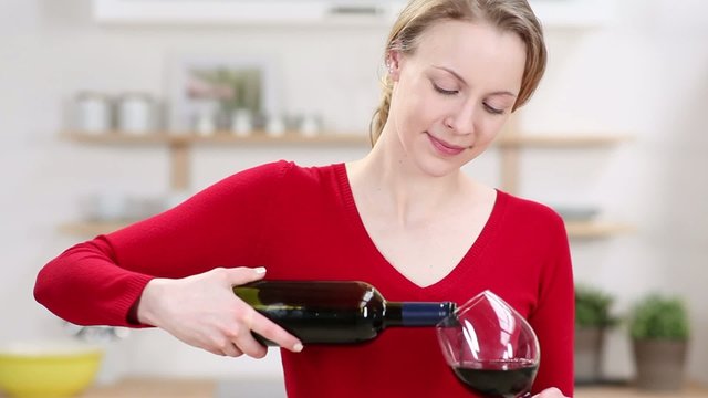junge frau schenkt wein ein