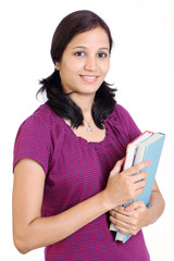 Smiling female student holding books