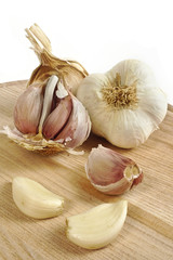 garlic on a chopping board and white background - still life