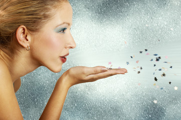 Young woman blowing little stars