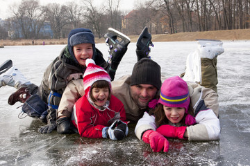 Tata z dziećmi na łyżwach