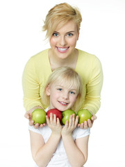 Fototapeta premium Blonde sisters with red and green apples