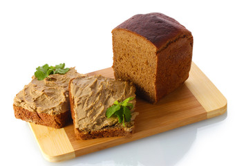 Fresh pate on bread on wooden board isolated on white