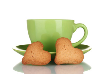 Green cup and saucer with heart-shaped cookies isolated on white