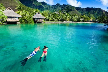 Foto op Plexiglas Young couple snorkeling in clean water over coral © Martin Valigursky