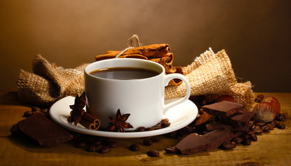 coffee cup and beans, cinnamon sticks, nuts and chocolate