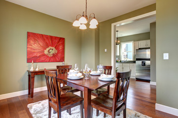 Dining room with green walls and cherry floor.