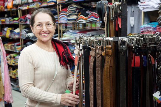 Mature woman  chooses  leather belt
