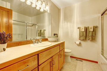 Outdated simple bathroom with wood cabinets,