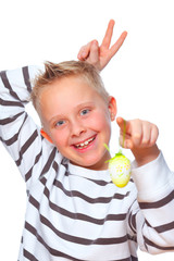 boy making rabbit ears behind his head and holding easter egg